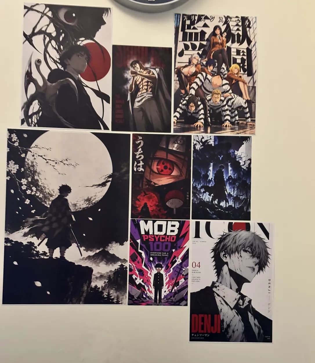 Collage of anime art prints on a cream wall: Denji, Mob Psycho 100, Itachi and more
