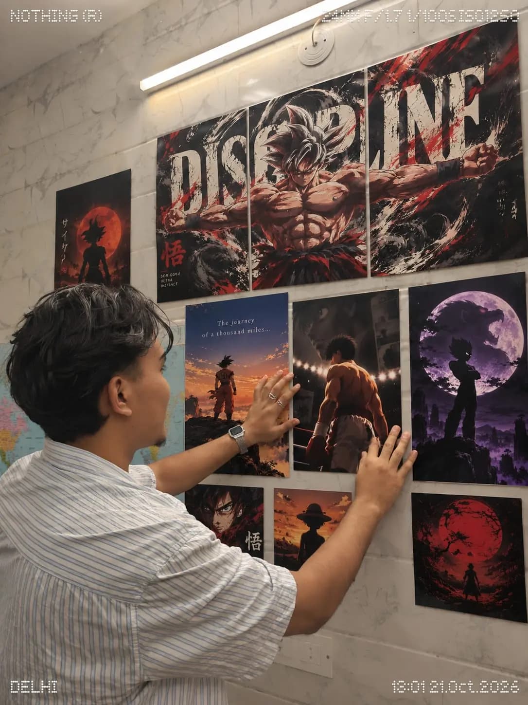 Customer pressing a Goku Discipline triptych and other anime posters onto a marble-tiled wall